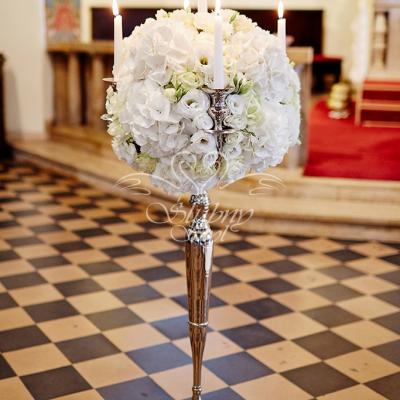 Dekoracja wysokiego świecznika żywymi kwiatami w kościele