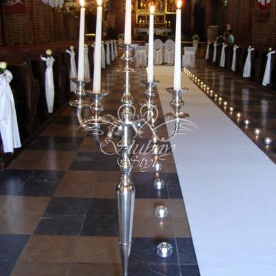 Srebrne wysokie kandelabry w dekoracji kościoła