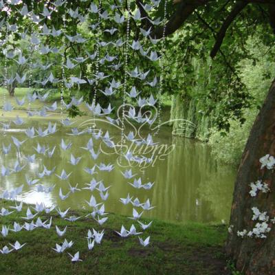 Papierowe origami - białe żurawie, żywe storczyki oplatające drzewo