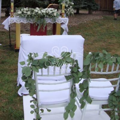 Ślub w plenerze dekoracja krzeseł girlandą z populusa